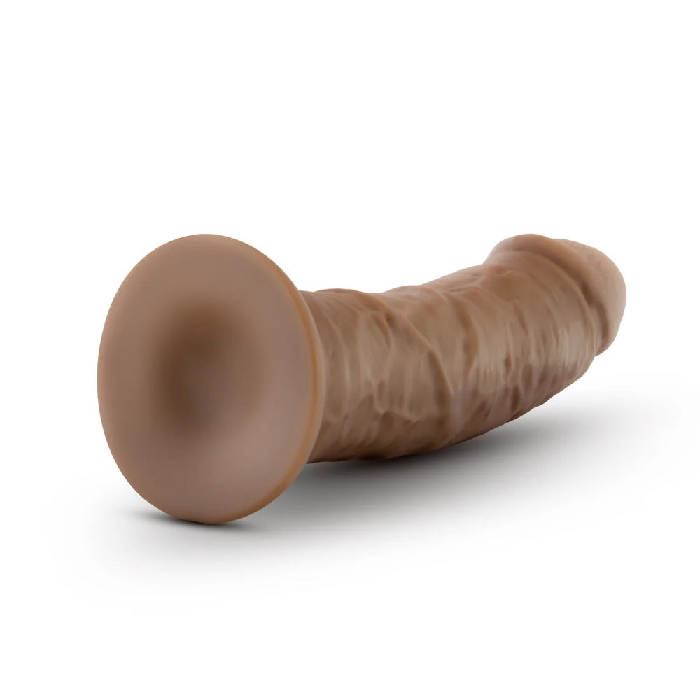Caramel Au Naturel Sensafeel 7.5 dildo with suction base laying horizontal to the ground with the suction base displayed