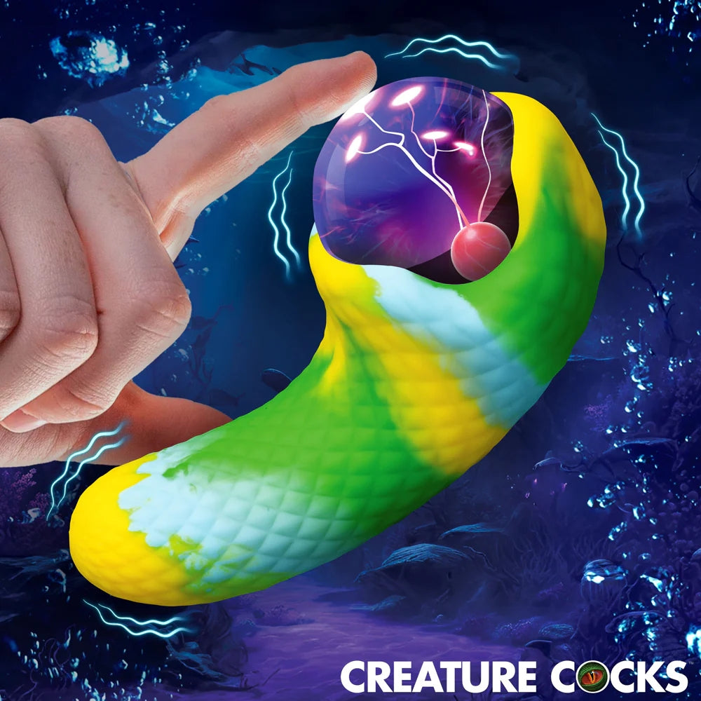 Electric Eye Green and Yellow plasma Creature Cocks Silicone Vibrator with finger touching plasma eye to show light up feature on graphic background