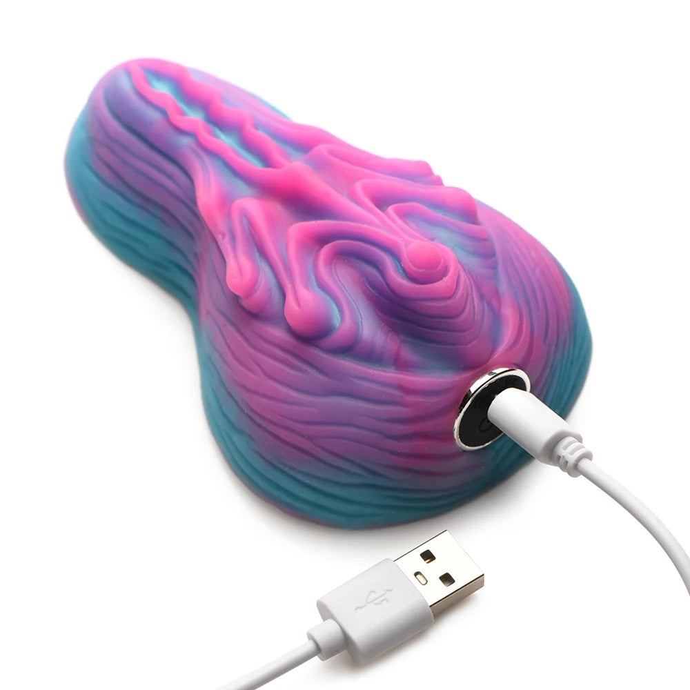Creature Cocks Vulvaron pink and blue silicone vulva- like fantasy vibrating rechargeable remote controlled silicone grinder with included charger plugged in