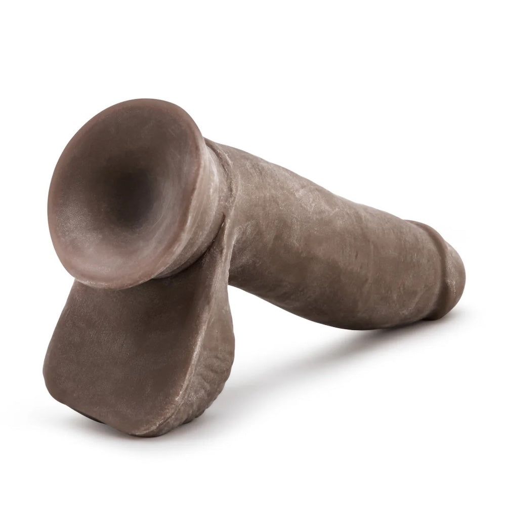 Chocolate Au Naturel dual density sensafeel dildo with balls and suction cup horizontal to the ground, with suction cup base exposed