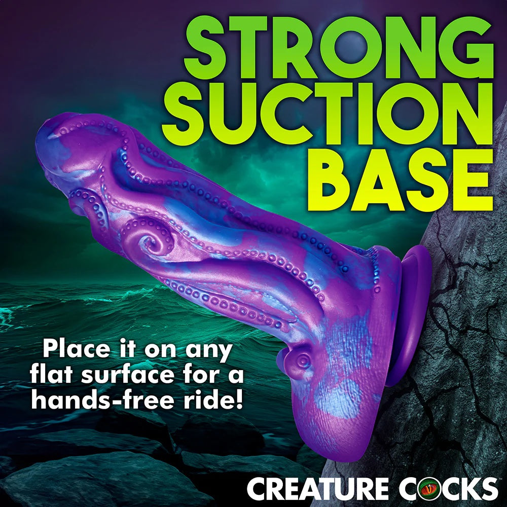XR brands octophallus purple and blue tentacle wrapped phallus silicone dildo with suction cup attached to a flat verticle surface to show suction cup strength