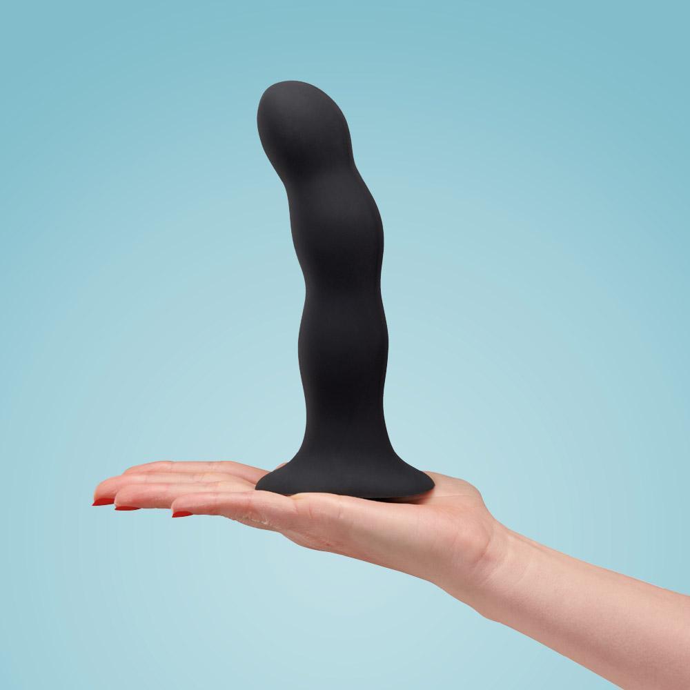 Fun Factory Bouncer dildo in colors black held in a hand.