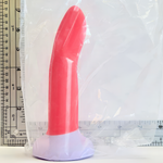 A curved guava silicone insert or toy wrapped in clear plastic, shown next to a ruler for scale on a white background.
