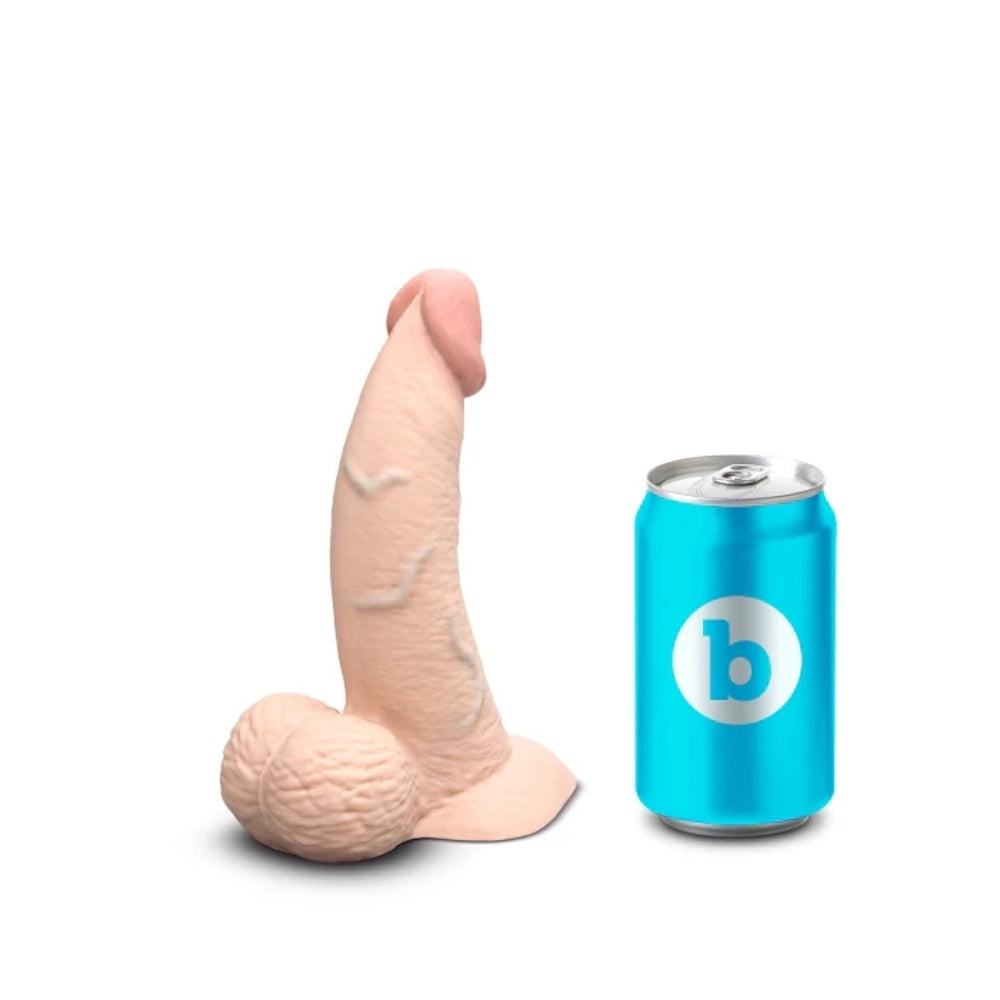 b Vibe Cream colored slip skin dildo, flat on its base with tip pointed up next to a standard soft drink can for size reference