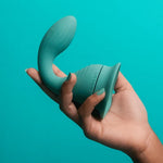 Banana Split dollop vibrator with its included suction base for stand alone use, in a hand