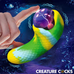 Electric Eye Green and Yellow plasma Creature Cocks Silicone Vibrator with finger touching plasma eye to show light up feature on graphic background