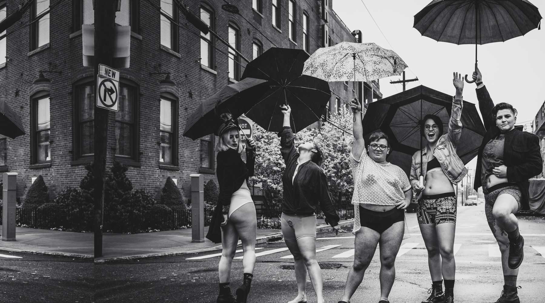 5 people in the street holding umbrellas