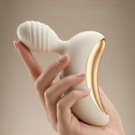 Lunar Curve silicone crescent moon shaped clitoral vibrator in white and gold with app control capability, from the side in a hand