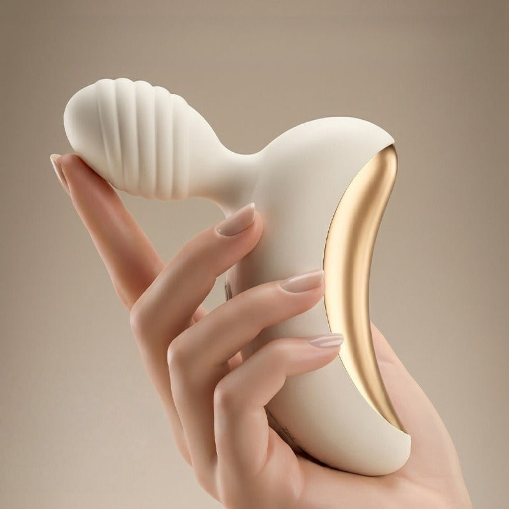 Lunar Curve silicone crescent moon shaped clitoral vibrator in white and gold with app control capability, from the side in a hand