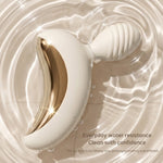 Lunar Curve silicone crescent moon shaped clitoral vibrator in white and gold with app control capability, from the side in shallow dish of water displaying splash proof capability
