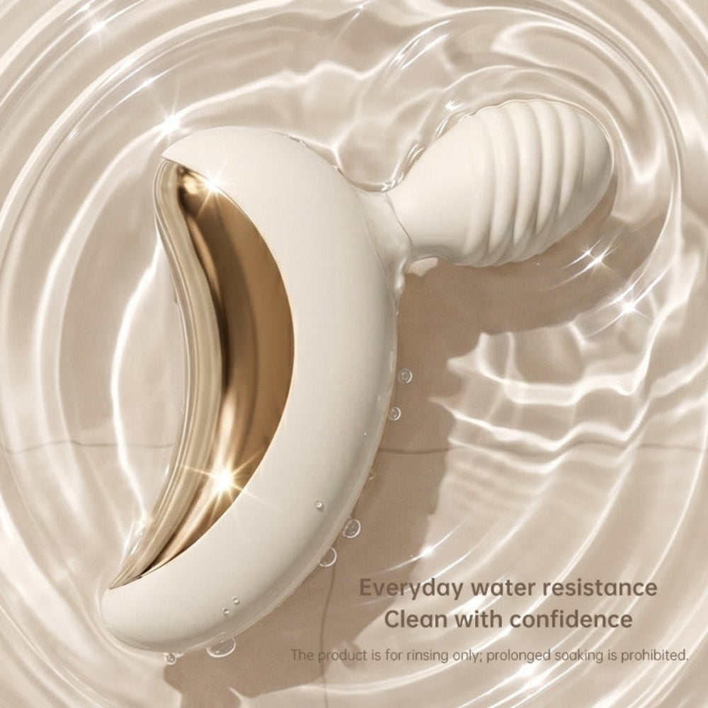 Lunar Curve silicone crescent moon shaped clitoral vibrator in white and gold with app control capability, from the side in shallow dish of water displaying splash proof capability