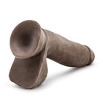 Chocolate Au Naturel dual density sensafeel dildo with balls and suction cup horizontal to the ground, with suction cup base exposed