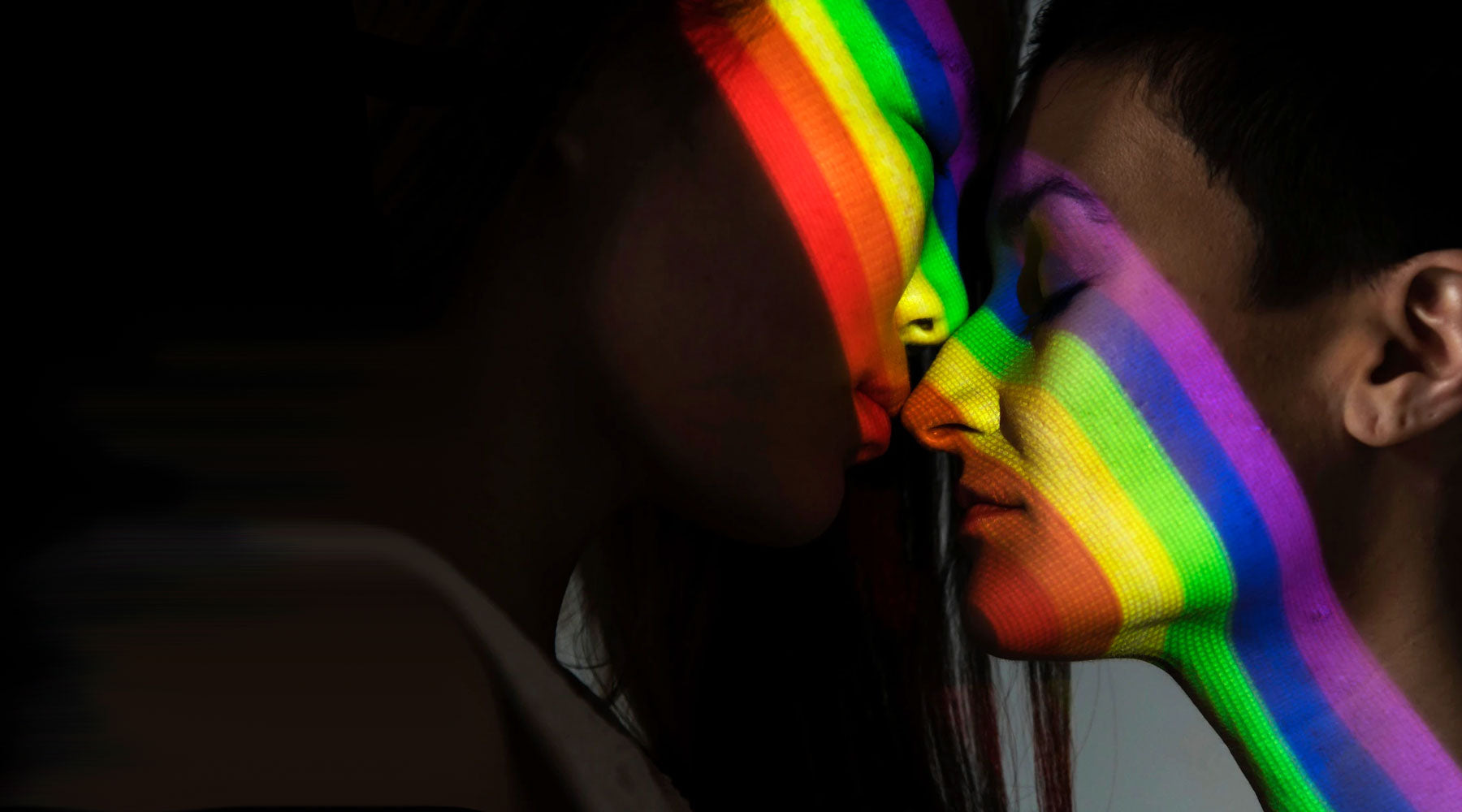 two women in shadow with rainbow light reflection on faces