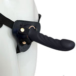 Nexus Fun and Love harness kit with adjustable black strap on harness and black tease silicone dildo, with dildo inserted into the harness and harness on a mannequin, angled from the side