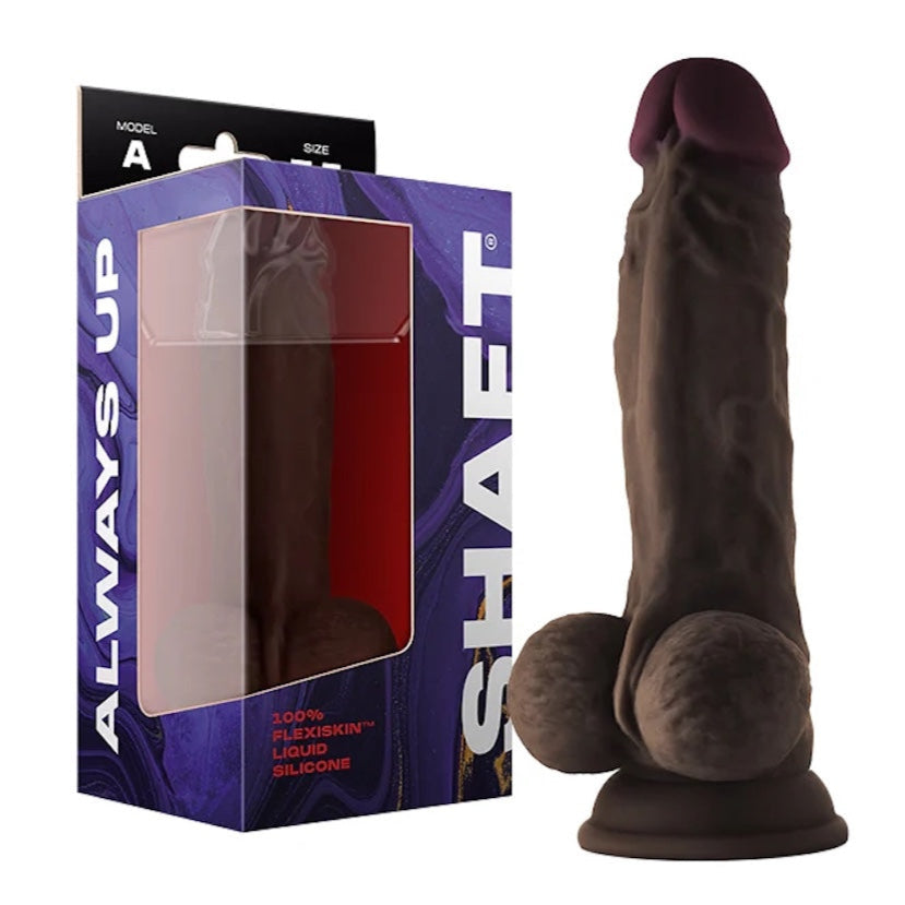 Shaft Model A silicone realistic dual density dildo with balls in Chocolate aka Mahogany with painted tip and suction cup base next to its packaging