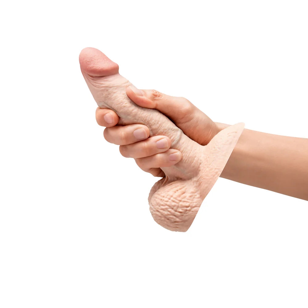 slipskin 6" cream silicone sliding skin dildo, in a hand to show ho the sliding skin moves