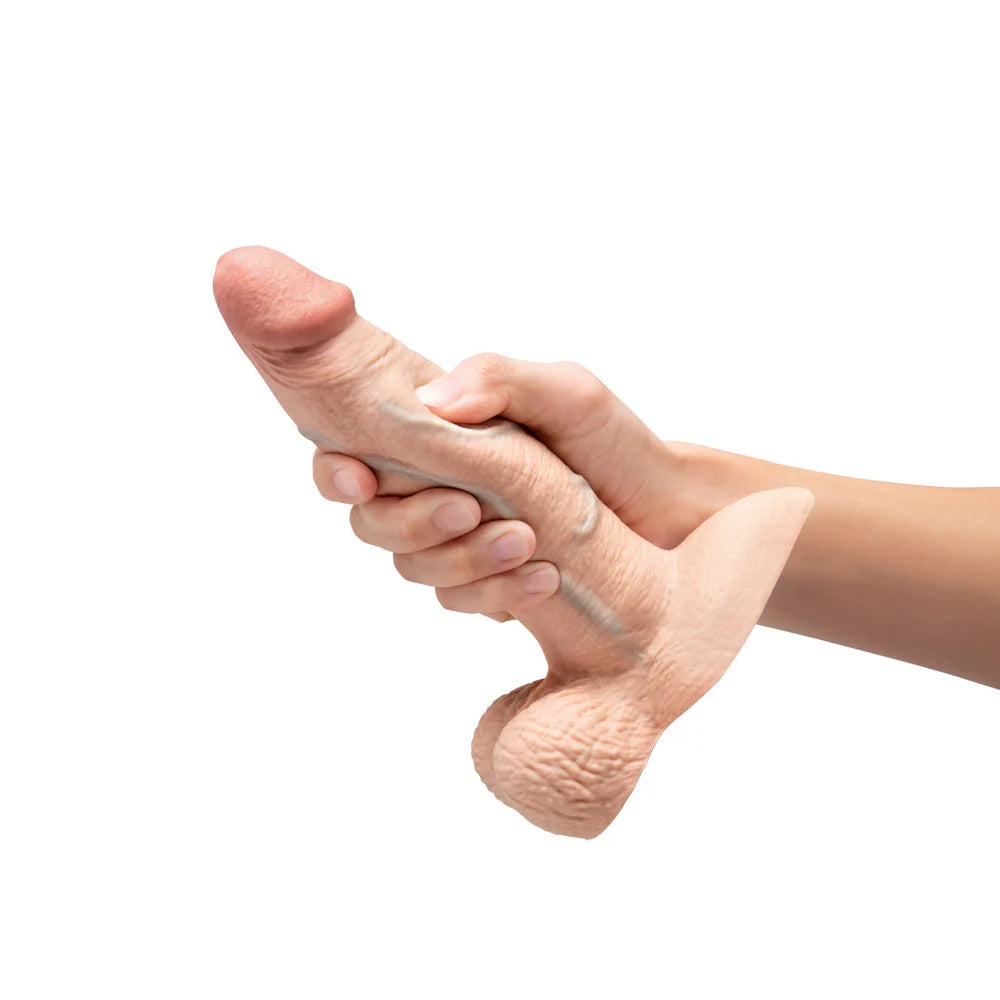 Slipskin Grithy Sliding Skin silicone dildo in Cream held in hand to show skin movement