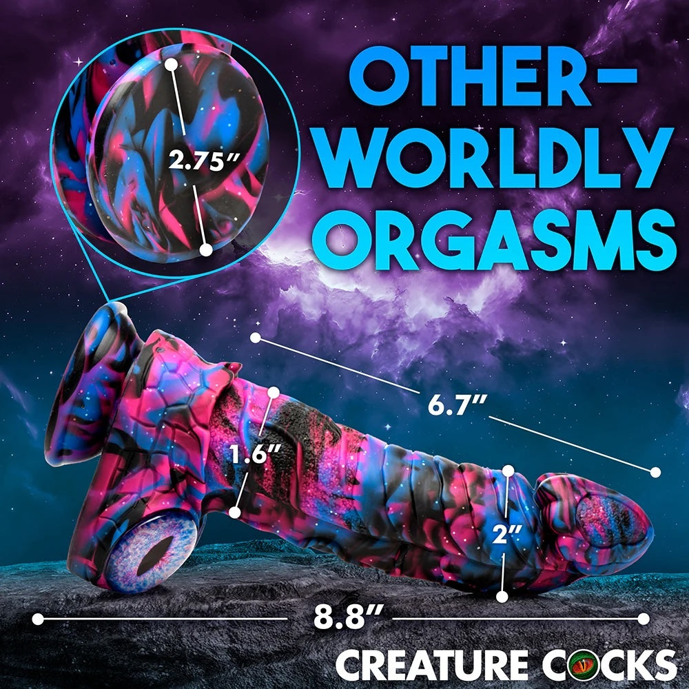XR Brands Creature Cocks Alienoid Pink, black, blue and glitter silicone fantasy dildo with eye balls for testes horizontal from the side, in a space scene background with graphic dimensions