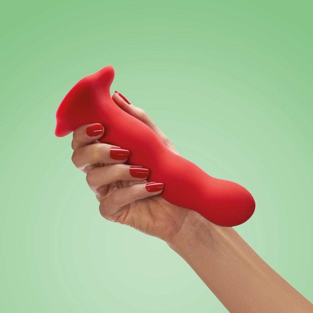 Fun Factory Bouncer dildo in color red held by a hand.